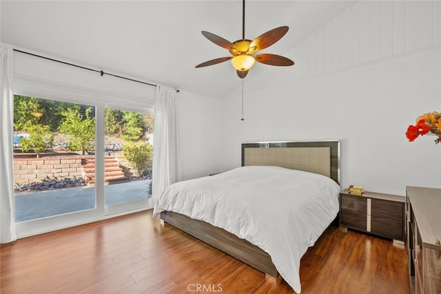 bedroom featuring access to exterior, vaulted ceiling, dark hardwood / wood-style floors, and ceiling fan