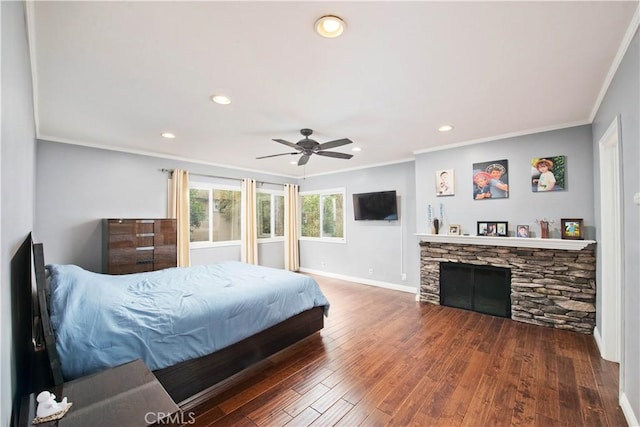 bedroom featuring a fireplace, dark wood-type flooring, ornamental molding, and ceiling fan