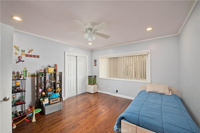 bedroom featuring ornamental molding, ceiling fan, dark hardwood / wood-style flooring, and a closet