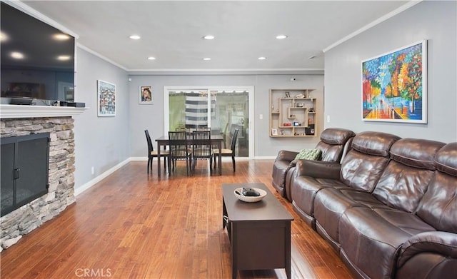 living room with a fireplace, wood-type flooring, and ornamental molding