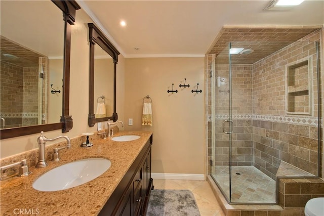 bathroom featuring a shower with door, ornamental molding, tile patterned floors, and vanity