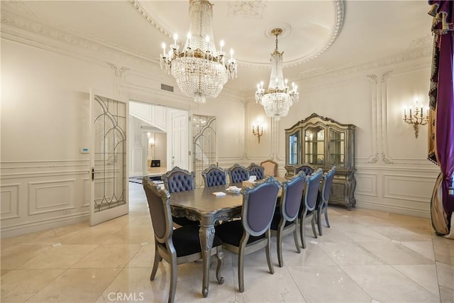 dining area with a wainscoted wall, an inviting chandelier, ornamental molding, a decorative wall, and light tile patterned floors