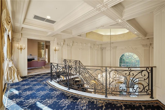 hallway featuring beam ceiling, visible vents, an upstairs landing, coffered ceiling, and ornamental molding