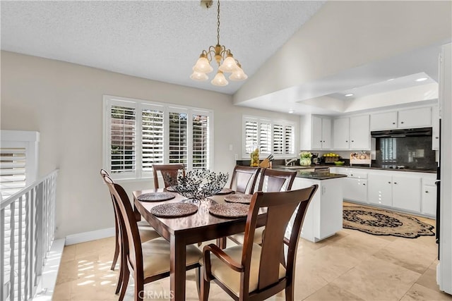 dining space with vaulted ceiling, sink, a textured ceiling, and an inviting chandelier