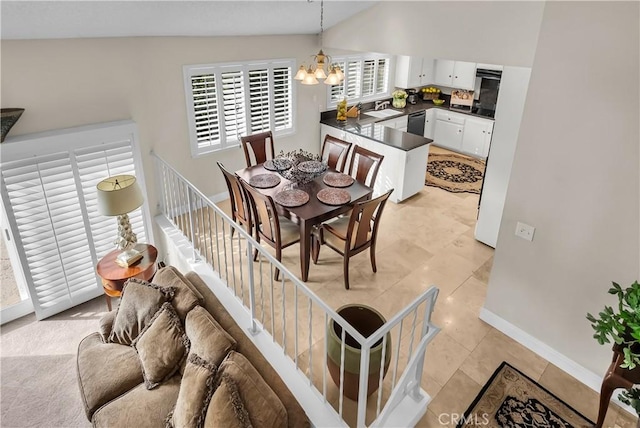 dining area featuring light tile patterned flooring, sink, and a chandelier