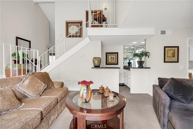 living room featuring a towering ceiling and carpet floors