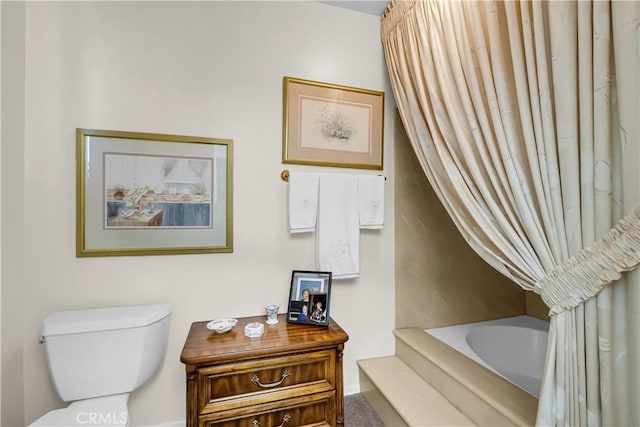 bathroom featuring a tub to relax in and toilet