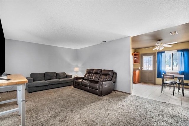 carpeted living room with a textured ceiling and ceiling fan