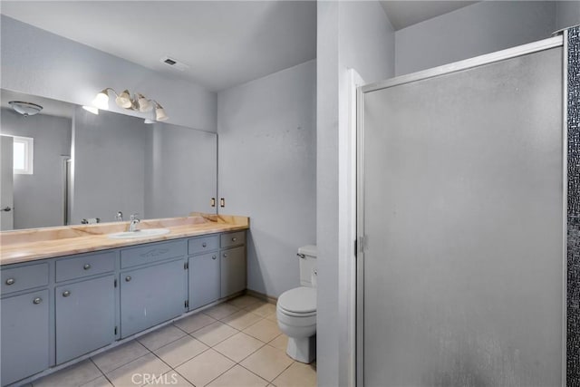 bathroom with tile patterned flooring, vanity, toilet, and a shower with shower door