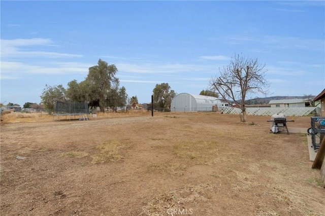 view of yard featuring a trampoline and a rural view