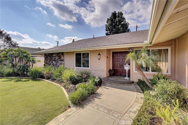 doorway to property featuring a lawn