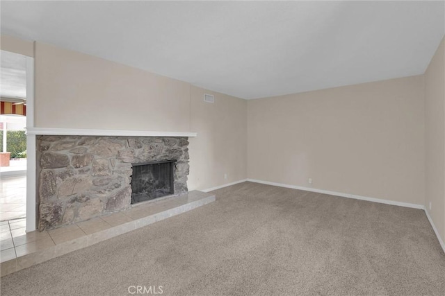 unfurnished living room with carpet flooring and a stone fireplace