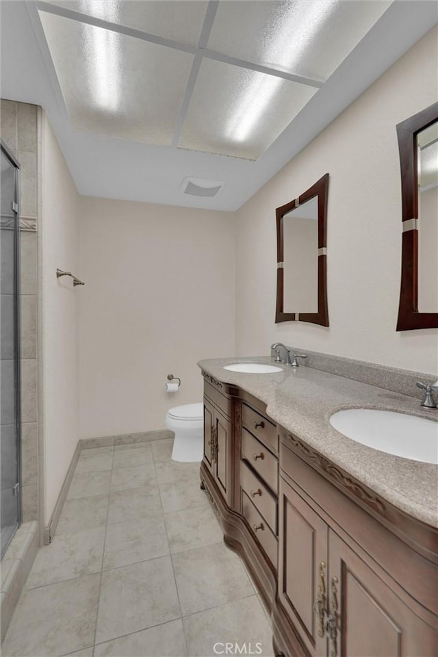 bathroom with vanity, tile patterned flooring, a shower with shower door, and toilet