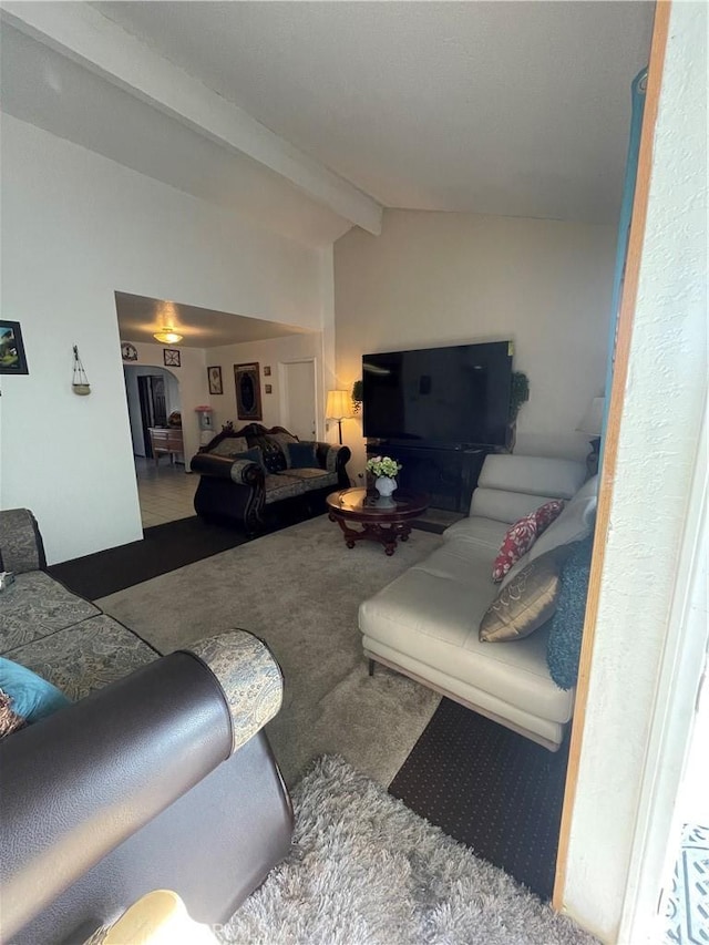 living room with lofted ceiling with beams and carpet flooring