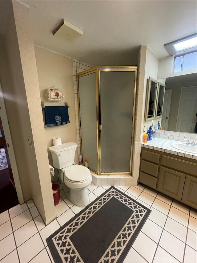 bathroom featuring tile patterned flooring, vanity, and walk in shower