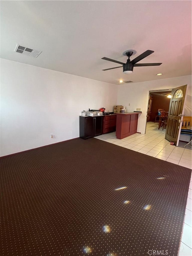 interior space with light carpet and ceiling fan