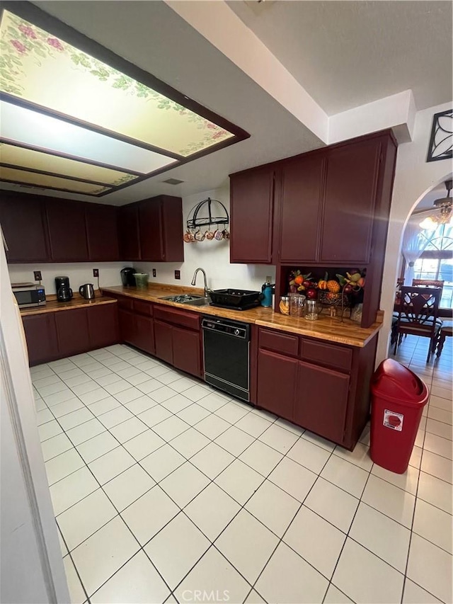 kitchen featuring wooden counters, black dishwasher, sink, and light tile patterned floors