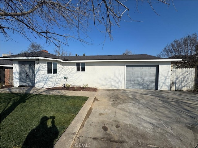 rear view of property featuring a garage and a lawn