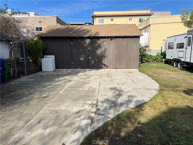 exterior space featuring washer / clothes dryer and an outbuilding
