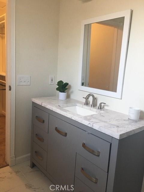 bathroom featuring marble finish floor and vanity