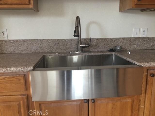 kitchen featuring brown cabinets and a sink