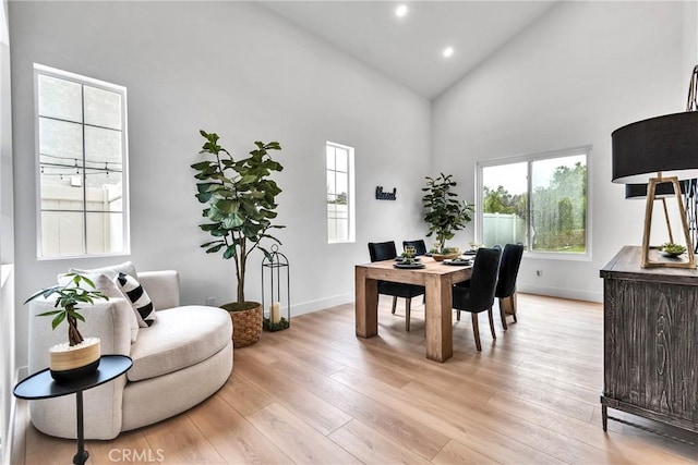 office with high vaulted ceiling and light hardwood / wood-style flooring