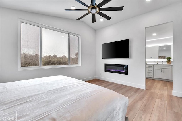 bedroom with lofted ceiling, sink, ensuite bath, light hardwood / wood-style flooring, and ceiling fan