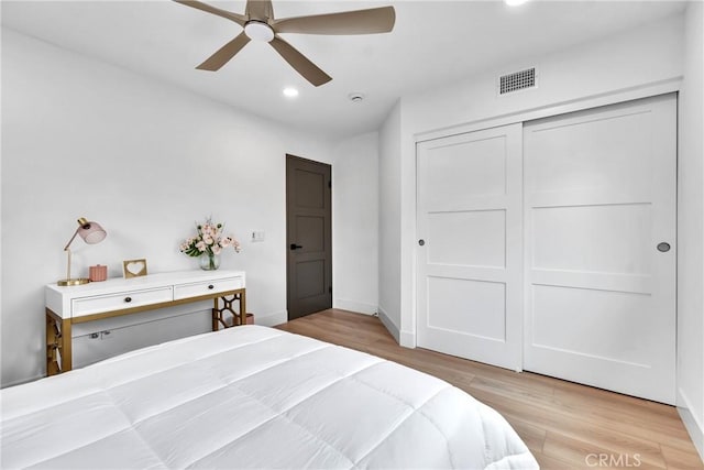 bedroom with a closet, ceiling fan, and light hardwood / wood-style flooring