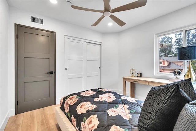 bedroom with hardwood / wood-style flooring, ceiling fan, and a closet