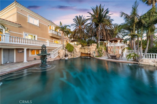 pool at dusk with a patio