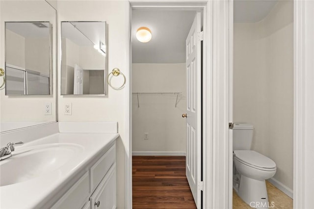 bathroom with hardwood / wood-style flooring, vanity, and toilet