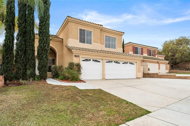 mediterranean / spanish home featuring stucco siding, concrete driveway, a front yard, and a tiled roof