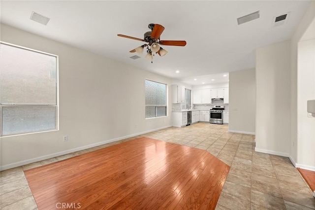 unfurnished living room with light tile patterned floors and ceiling fan