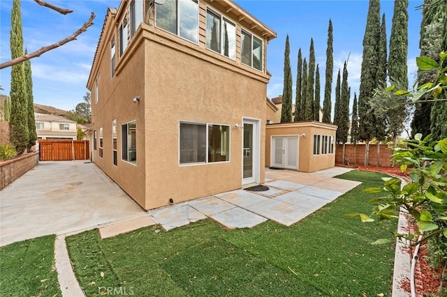 back of property featuring a patio area and a lawn