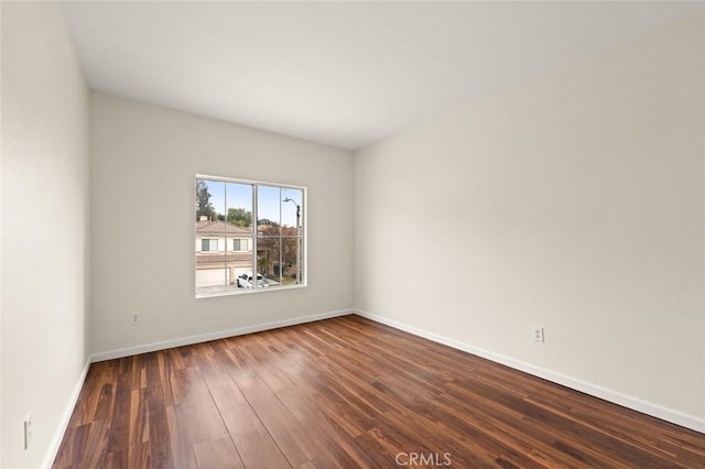 unfurnished room with dark wood-type flooring