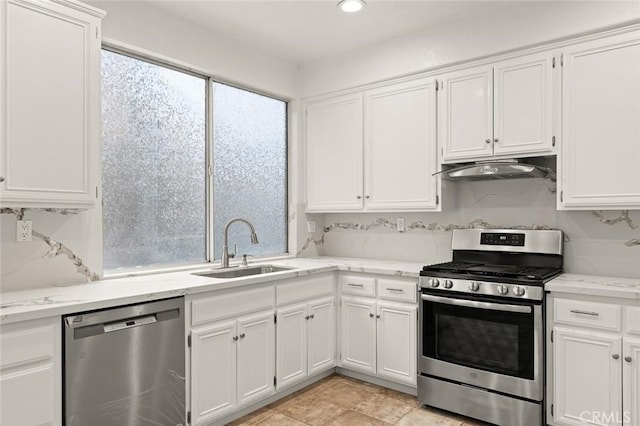 kitchen with white cabinetry, sink, decorative backsplash, light stone counters, and stainless steel appliances