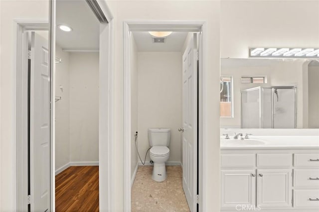 bathroom featuring toilet, vanity, and walk in shower