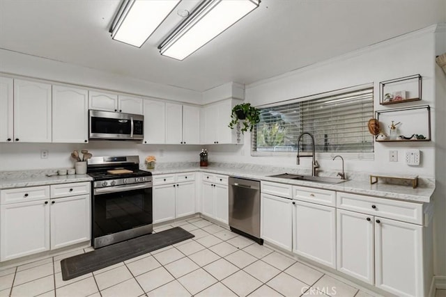 kitchen with stainless steel appliances, sink, white cabinets, and light stone counters