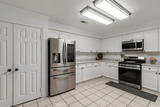 kitchen featuring white cabinetry, stainless steel appliances, crown molding, and light tile patterned floors