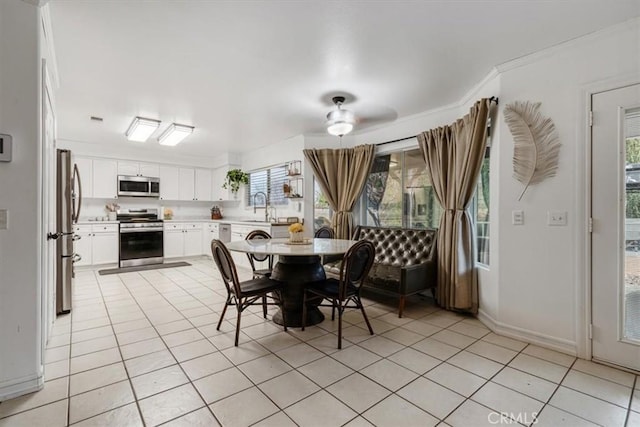 dining room featuring crown molding, sink, and light tile patterned floors