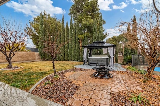 view of patio / terrace featuring a fire pit, a gazebo, and a hot tub