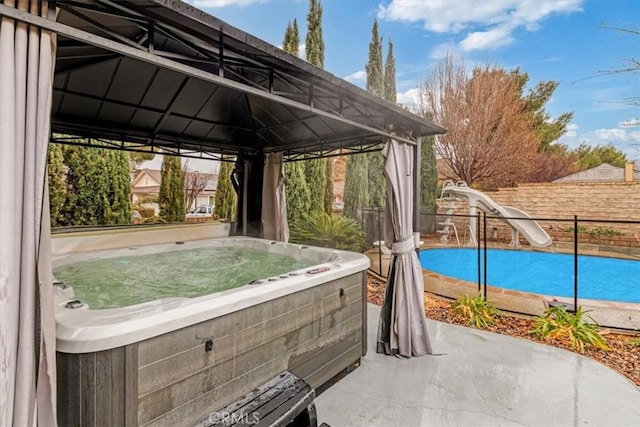 view of patio / terrace with a hot tub and a gazebo