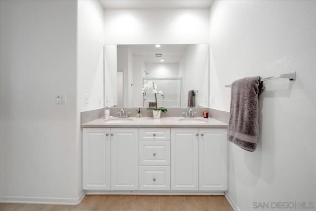 bathroom with vanity and a shower with door