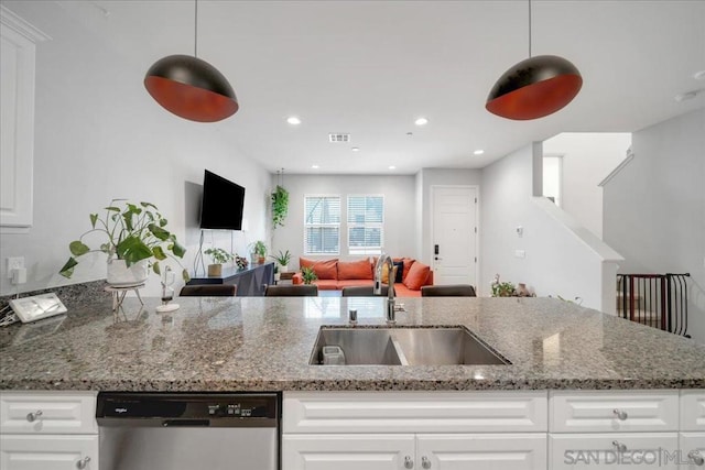 kitchen with white cabinetry, sink, decorative light fixtures, and stainless steel dishwasher