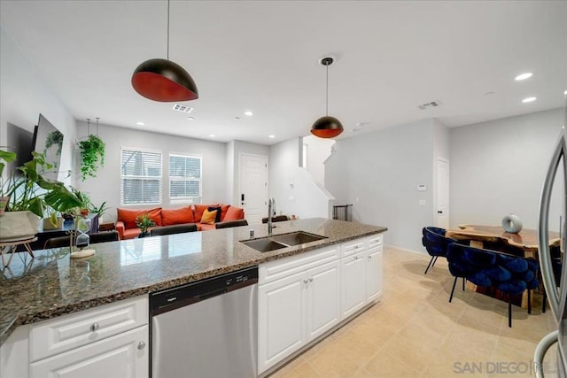 kitchen featuring white cabinetry, stainless steel appliances, sink, and hanging light fixtures