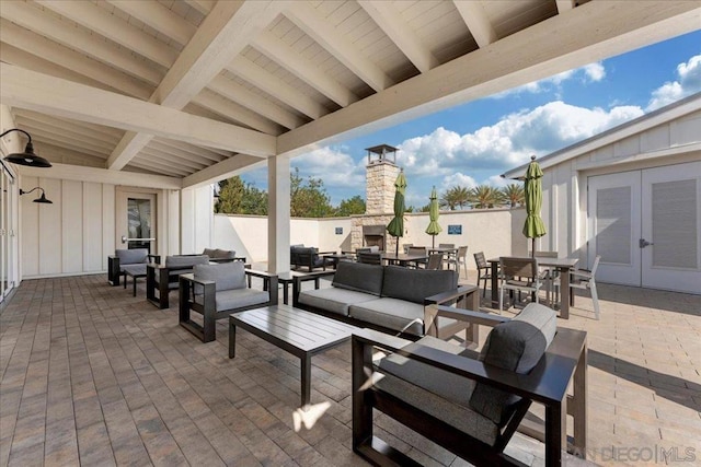 view of patio with an outdoor living space with a fireplace and french doors