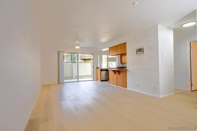 unfurnished living room with ceiling fan and light hardwood / wood-style flooring