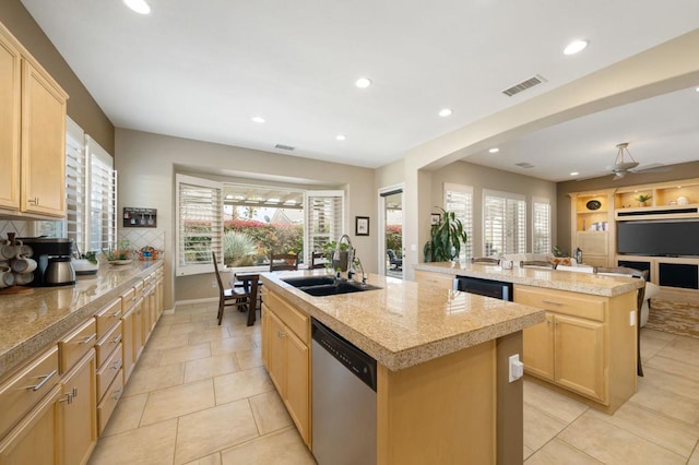 kitchen featuring sink, a kitchen island with sink, stainless steel dishwasher, and light brown cabinets