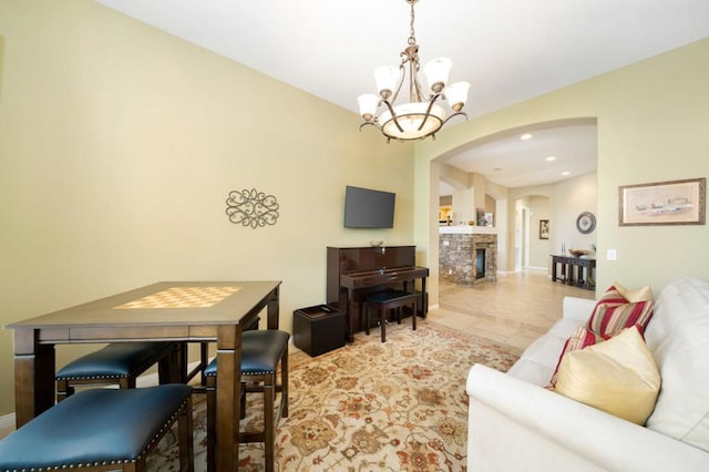 living room with a stone fireplace and a notable chandelier