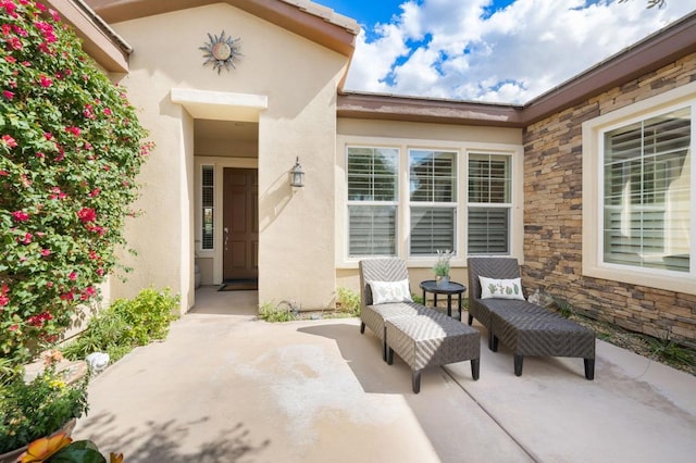 view of exterior entry with a patio area